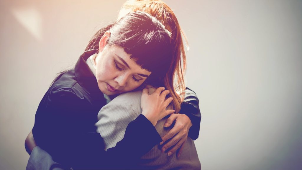 Two people embracing in support during addiction recovery