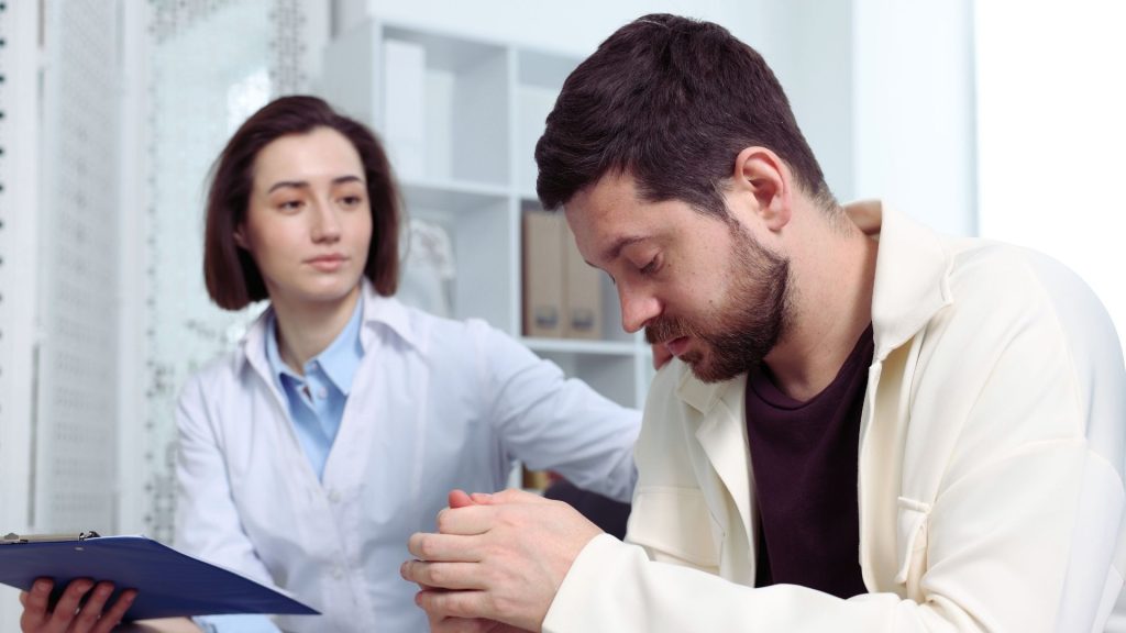 A clinician comforting a patient during a discussion about opioid use and treatment options.