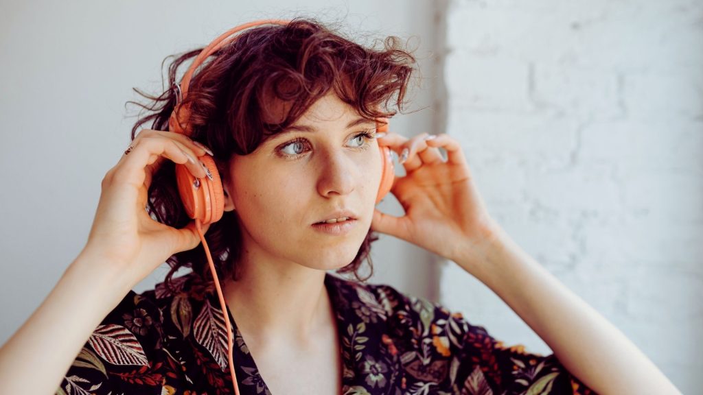 Person wearing headphones, appearing focused but emotionally distant